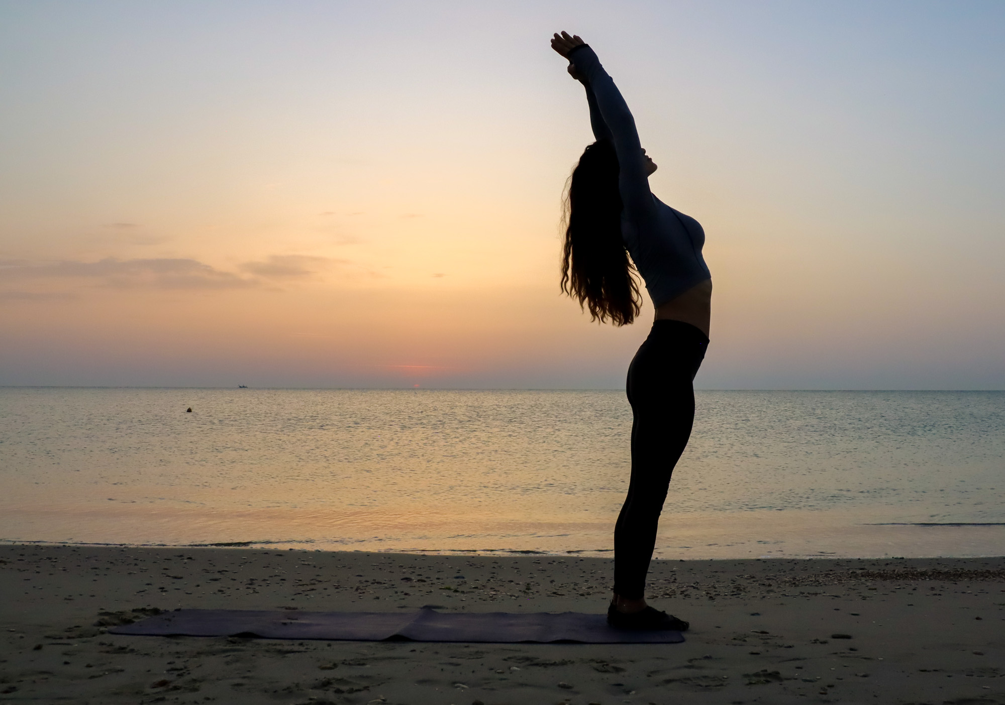 woman alone at dawn on beach with sunrise